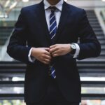 man buttoning suit jacket