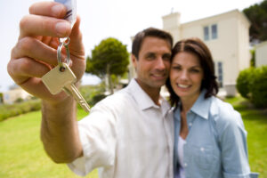 Couple holding a key in front of a house