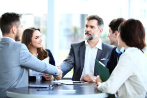 group shaking hands meeting table